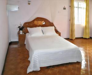 a bedroom with a large bed with white sheets at Spacious house in Grand Baie with shared pool in Grand Baie
