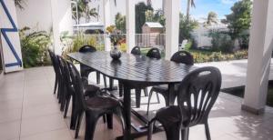 a black dining table and chairs on a patio at Villa de luxe à Saint Francois, piscine in Saint-François