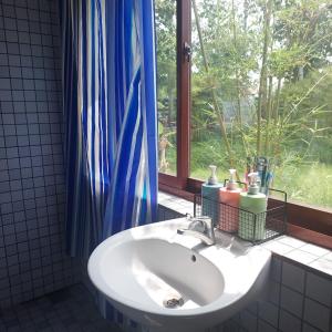 a white sink in a bathroom with a window at Lux Home Phước Hải 2 in Hội Mỹ