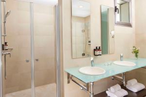 a bathroom with two sinks and a shower at NH Alicante in Alicante