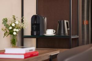 a table with a coffee maker on a shelf at NH Alicante in Alicante