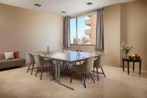 a dining room table with chairs and a large window at NH Alicante in Alicante