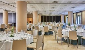 a banquet hall with white tables and chairs at NH Alicante in Alicante