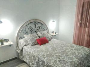 a bedroom with a large bed with a red pillow on it at Charming chalet in Prado del Rey with private pool in Prado del Rey