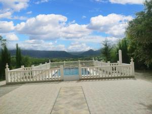 a white fence next to a swimming pool at Charming chalet in Prado del Rey with private pool in Prado del Rey