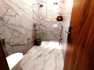 范兰德凡Premium Homestay Near Banke Bihari Ji with Power Backup - Free WiFi - Washing Machine etc的浴室设有白色大理石墙壁和卫生间。