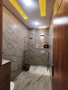 范兰德凡Premium Homestay Near Banke Bihari Ji with Power Backup - Free WiFi - Washing Machine etc的浴室配有水槽和带大理石墙壁的淋浴。 更多37张照片