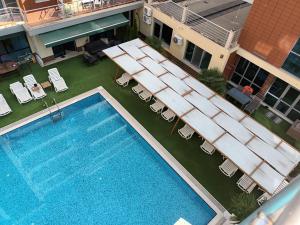 una vista sul soffitto di una piscina con sedie e di un hotel di Apartament Milenium a Pomorie