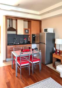 a kitchen with a table and chairs and a refrigerator at Charming Apartment in Estômbar with Private Pool. in Estômbar