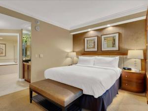 - une chambre avec un grand lit blanc et un banc dans l'établissement Ultimate Vegas Trip with Sphere View, Pool and Gym, à Las Vegas
