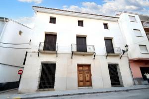 ein weißes Gebäude mit brauner Tür auf einer Straße in der Unterkunft Charming House in Ayora + Terrace in Ayora
