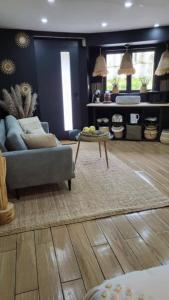 a living room with a couch and a table at Logement proche de la mer in Bernières-sur-Mer