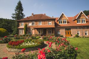 a large brick house with a garden of flowers at Landhaus Schulze Osthoff in Warendorf