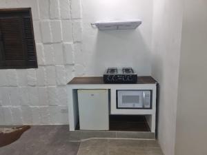 a counter with a microwave and a stove on it at Sitio Azeite com Pimenta in Itabirito