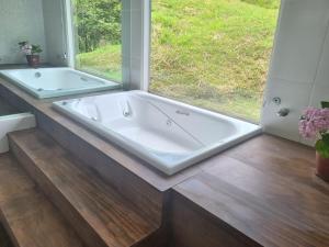 a large bath tub in a bathroom with a window at Sitio Azeite com Pimenta in Itabirito