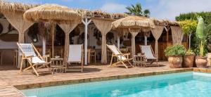 a group of chairs and umbrellas next to a pool at Can Aisha in Es Pujols