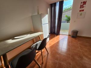 a kitchen with a counter with chairs and a refrigerator at Autonomia House III in Câmara de Lobos