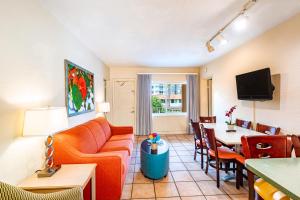 ein Wohnzimmer mit Sofa und Tisch in der Unterkunft Enchanted Isle Hollywood Beach Resort in Hollywood