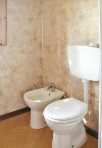 a bathroom with a white toilet and a sink at Bungalow confortable à Santa-Lucia-di-Moriani 38 m² jardin spacieux in Santa-Lucia-di-Moriani