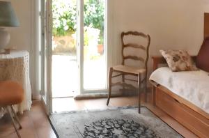 a bedroom with a chair and a bed and a window at Appartement confortable à Hyères avec terrasse in Hyères