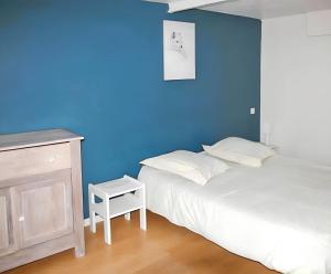 a bedroom with a blue wall and a bed and a table at Maison familiale spacieuse à Saint-Claude, vue sur la rivière in Saint-Claude