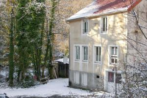 a house in the snow next to a fence at Maison familiale spacieuse à Saint-Claude, vue sur la rivière in Saint-Claude