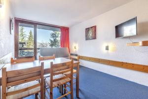 une salle à manger avec une table et des chaises et une fenêtre dans l'établissement Studio confortable à Bourg-Saint-Maurice, 30 m², vue montagne, à Bourg-Saint-Maurice
