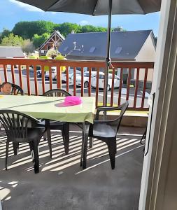a table and chairs on a balcony with an umbrella at Maison accueillante à La Salvetat-sur-Agout avec terrasse in La Salvetat +20 photos