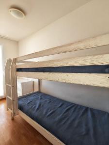 a bedroom with a bunk bed with blue sheets at Appartement convivial Le Verdon 35 m² piscine partagée in Le Verdon-sur-Mer
