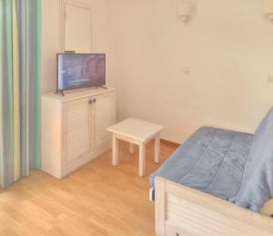 a bedroom with a bed and a tv on a dresser at Appartement convivial Le Verdon 35 m² piscine partagée in Le Verdon-sur-Mer