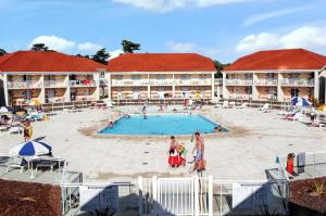 a resort with a swimming pool and people in it at Appartement convivial Le Verdon 35 m² piscine partagée in Le Verdon-sur-Mer