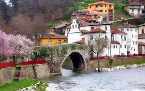 eine Brücke über einen Fluss in einer Stadt mit Gebäuden in der Unterkunft Charming apartment in San Antolin 35 m² with shared pool in San Antolín