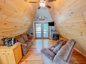 un soggiorno con divani e ventilatore a soffitto di Lake Life, Hocking Hills, Hot Tub, Fireplace, Pond a Rockbridge
