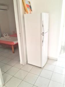 a white refrigerator in a room with a bedroom at Studio charmant à Sainte-Anne avec piscine partagée - 30 m² in Sainte-Anne
