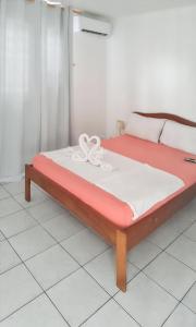 a bed in a room with a red and white mattress at Studio charmant à Sainte-Anne avec piscine partagée - 30 m² in Sainte-Anne