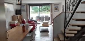 a living room with a table and chairs and a staircase at Villa avec Piscine - Vue Mer - Plougonvelin in Plougonvelin