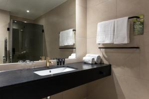 a bathroom with a sink and a mirror and towels at Clarion Hotel Air in Sola