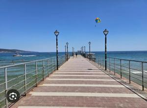 un muelle en la playa con gente caminando en él en Studio 39, en Sunny Beach