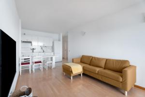 a living room with a brown couch and a kitchen at Apto Bajamar Seaview in Bajamar
