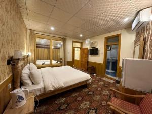 a bedroom with a bed and a tv in it at Eagle's Nest Hotel in Karimabad Hunza