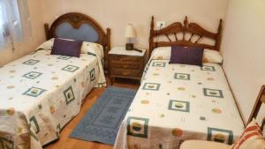 a bedroom with two twin beds and a night stand at Elegant Villa in Tui with Private Pool in Tui +27 photos
