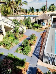 a patio with a garden and a swimming pool at Studio charmant à Grand Popo avec piscine partagée - 40 m² in Grand-Popo