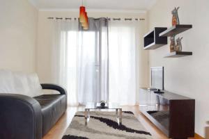 un soggiorno con un divano e una televisione di Chic Apartment Ribeira Grande 60 m² + balcony a Ribeira Grande