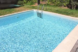 Una piscina con agua azul en un patio. en Spacious house with sea view in Caniço + private pool, en Caniço