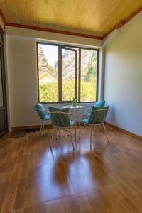 a dining room with a table and chairs and windows at Xuân Bách Family Motel in Nguyên Ngoại