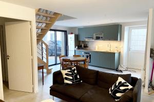 a living room with a brown couch and a kitchen at TY BIHAN Plage à 300m Bourg 500m in Piriac-sur-Mer
