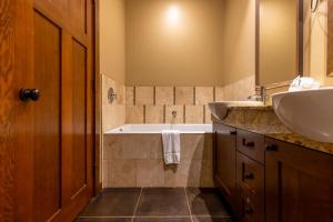 a bathroom with two sinks and a bath tub at The Historic 901 Condos In the Heart of Fernie in Fernie +70 photos