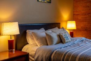 een slaapkamer met een bed met kussens en 2 lampen bij The Historic 901 Condos In the Heart of Fernie in Fernie