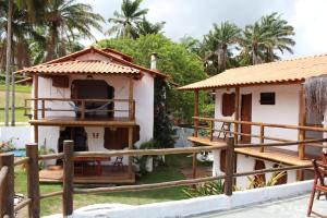 a small house with a porch and a fence at Pousada Cavallitos d'Amar in Ilha de Boipeba