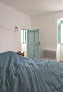 a bedroom with a bed and a green door at Appartement charmant à Algajola avec terrasse in Algajola